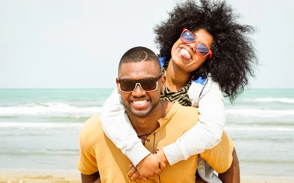 Happy Black couple smiling at the beach